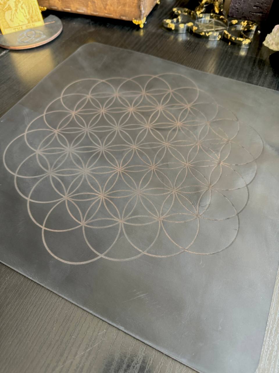 a metal surface with a geometric design consisting of concentric circles, resembling a flower or mandala pattern.