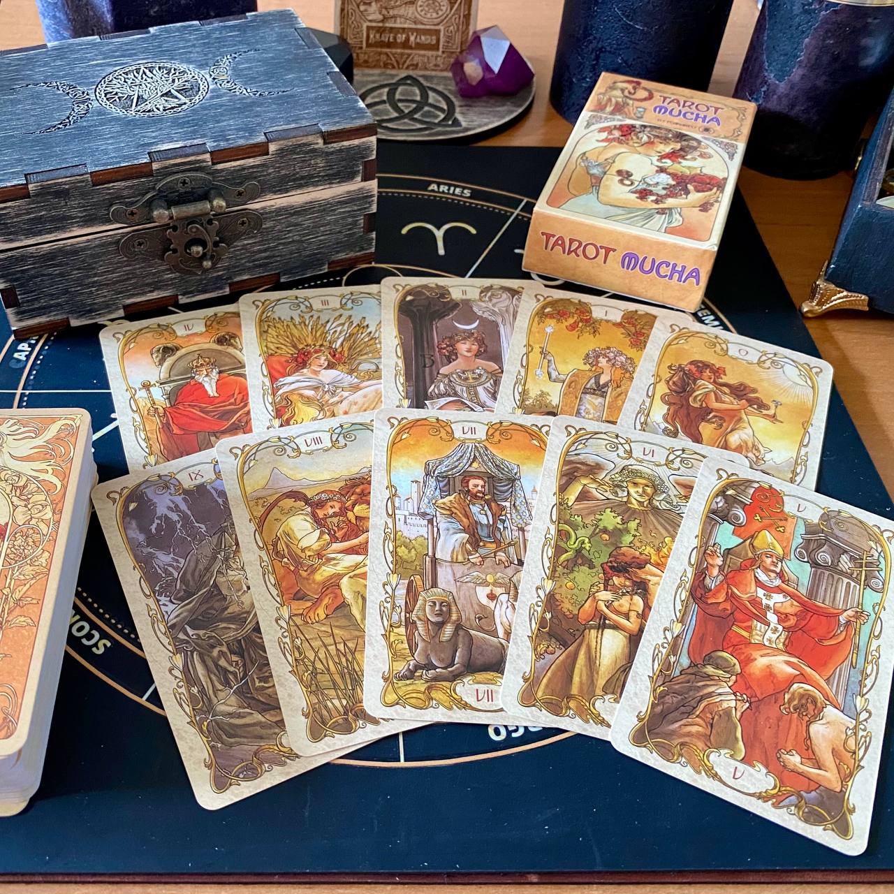 a collection of tarot cards and a wooden box, arranged on a table.