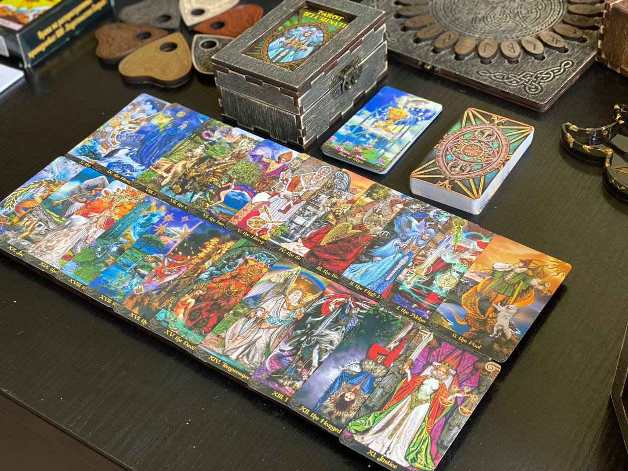 a collection of tarot cards, a wooden box, and various other objects arranged on a table.