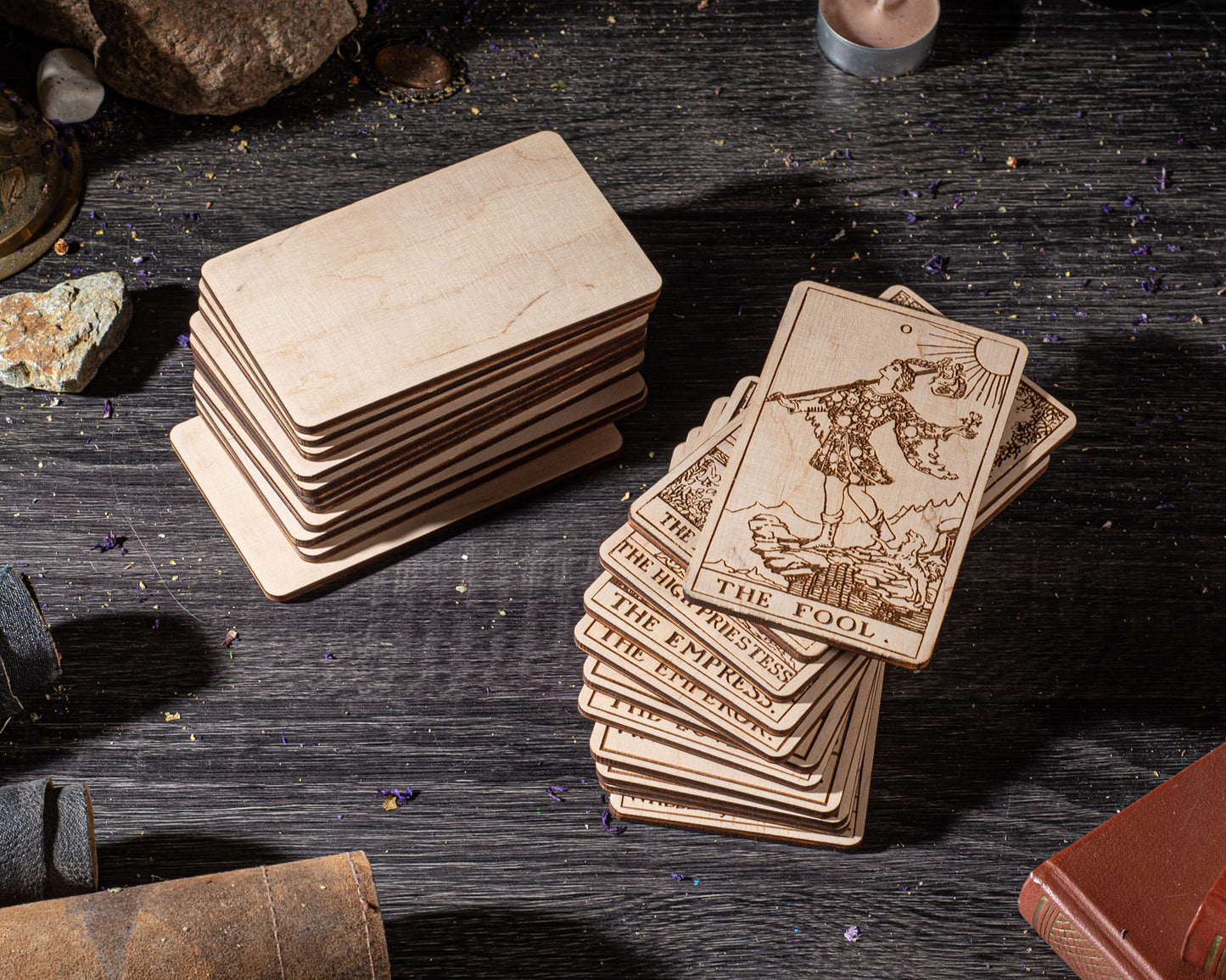 a collection of wooden tarot cards stacked on a wooden surface, with a stack of blank cards placed next to them.