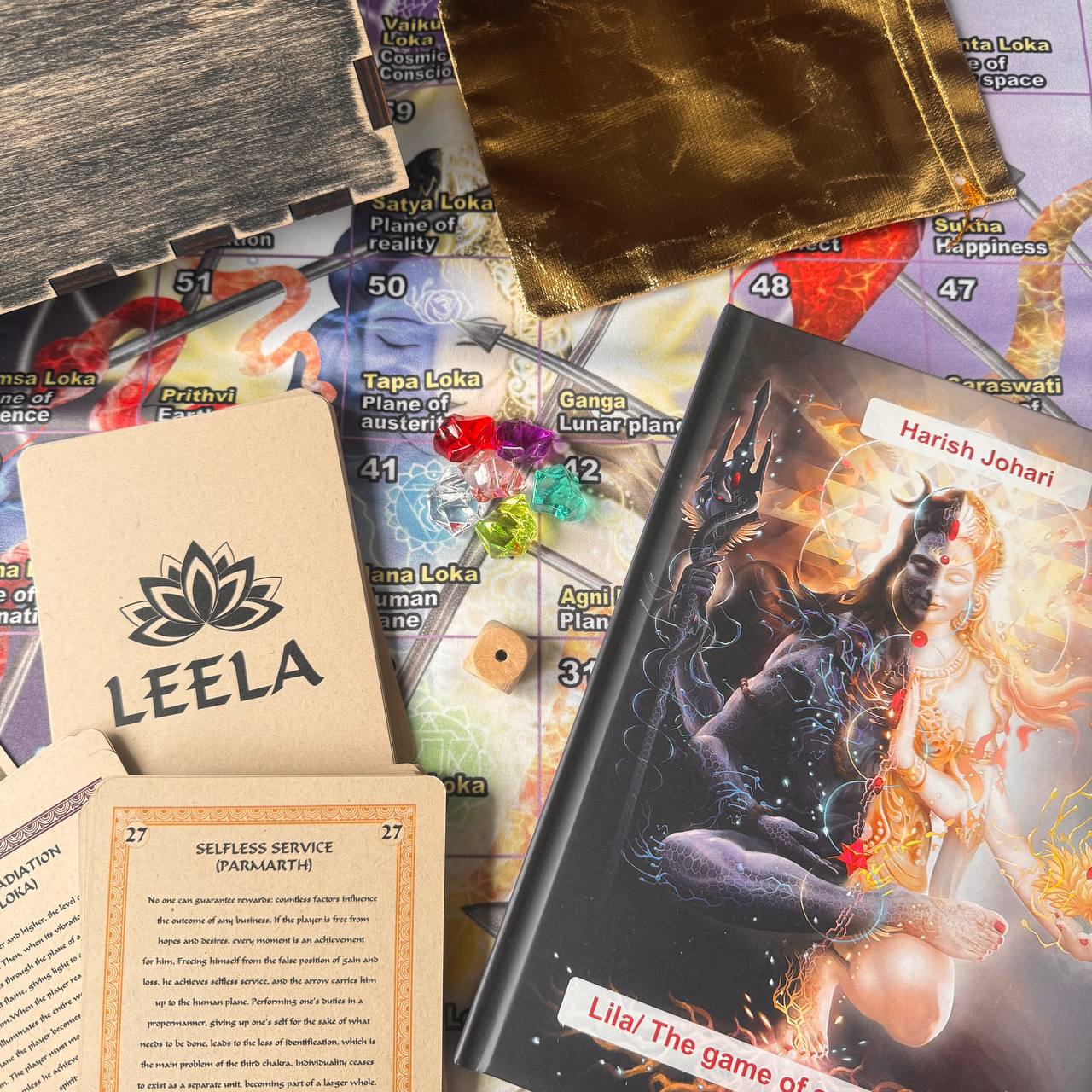a collection of items related to a board game, including a book, a card, and a game board. The book appears to be a game manual or instruction guide, while the card and game board are part of the game setup.