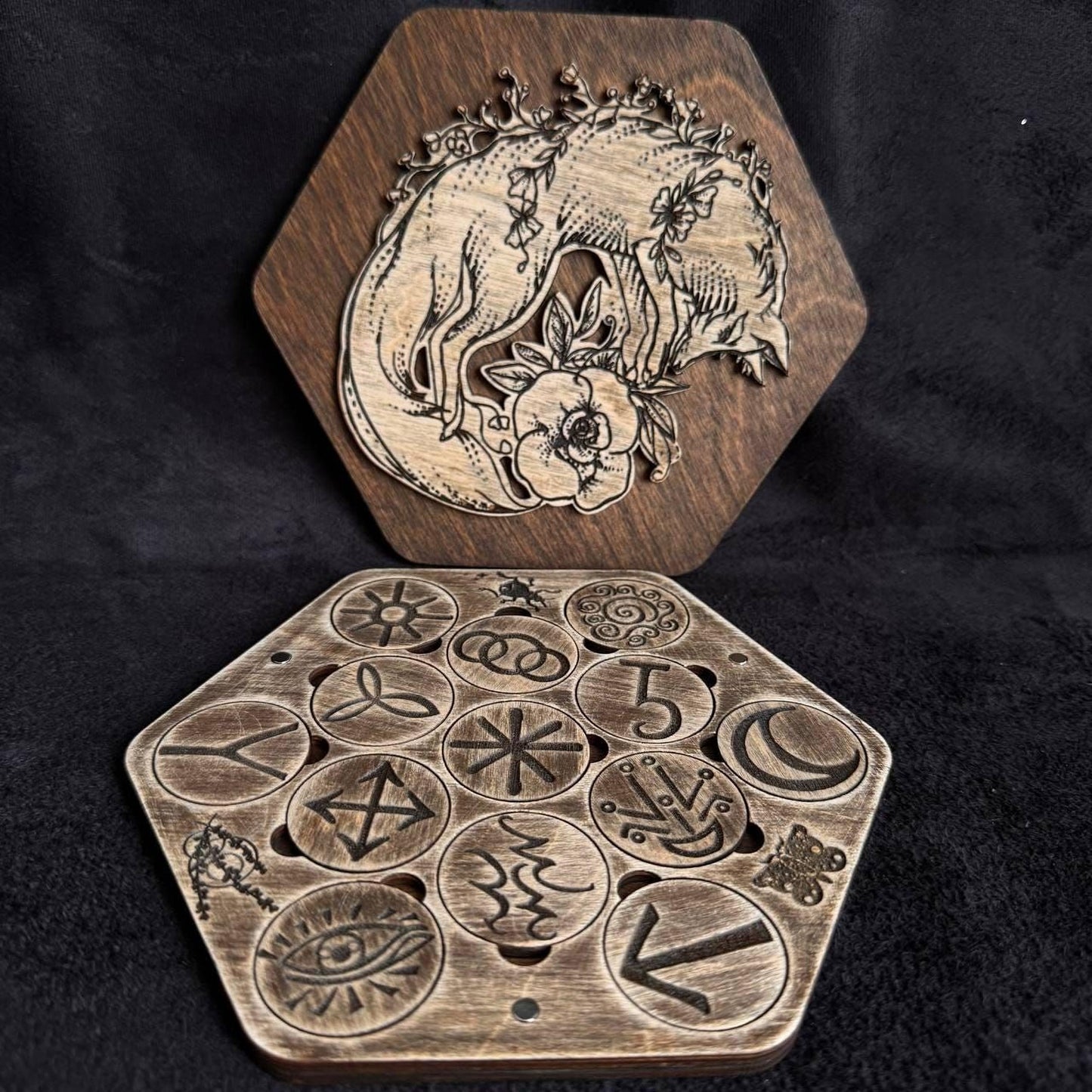a wooden hexagonal tray with various symbols and designs carved into it, and a wooden hexagonal tray with a carved image of a bear.
