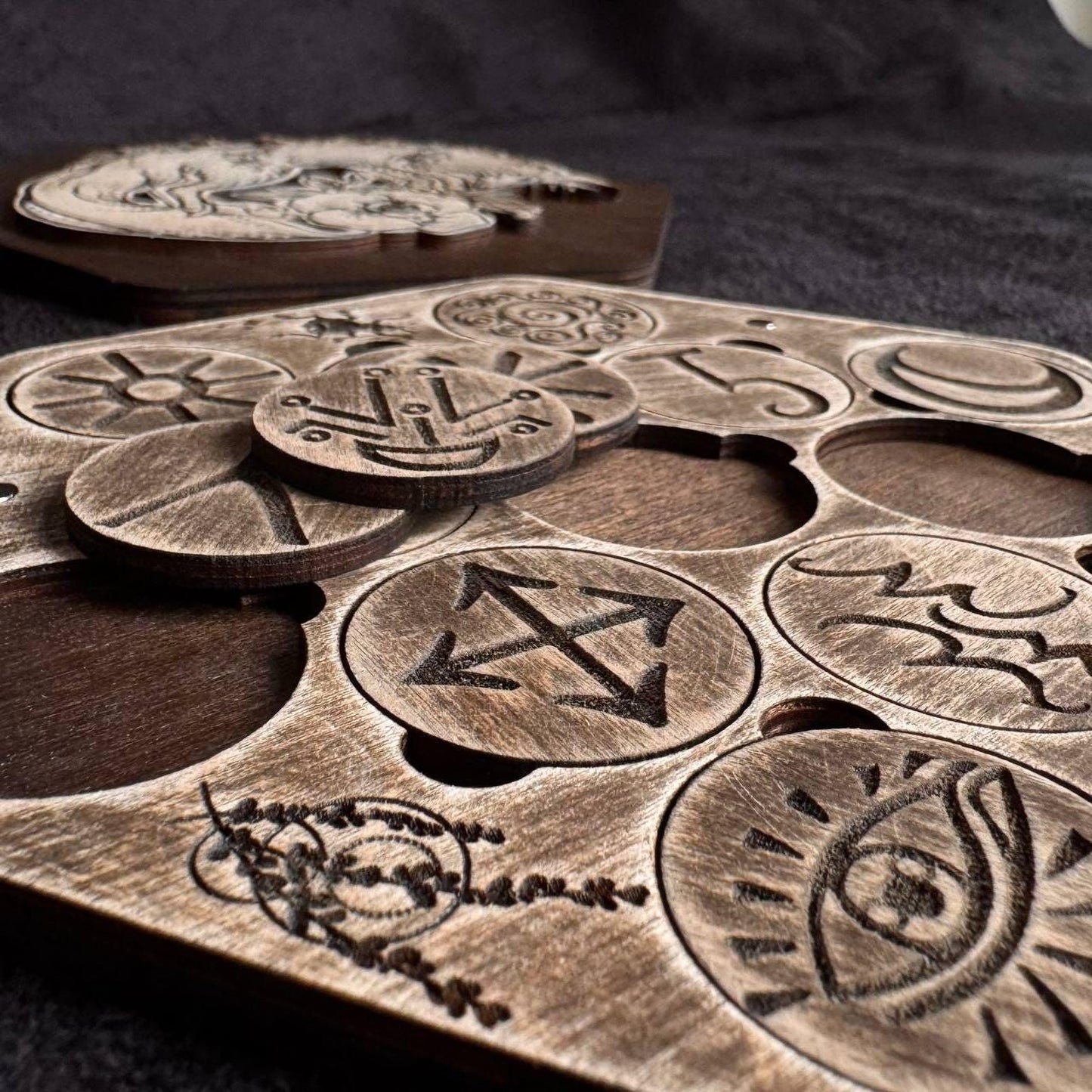 a close-up view of a wooden puzzle with various carved symbols and designs.