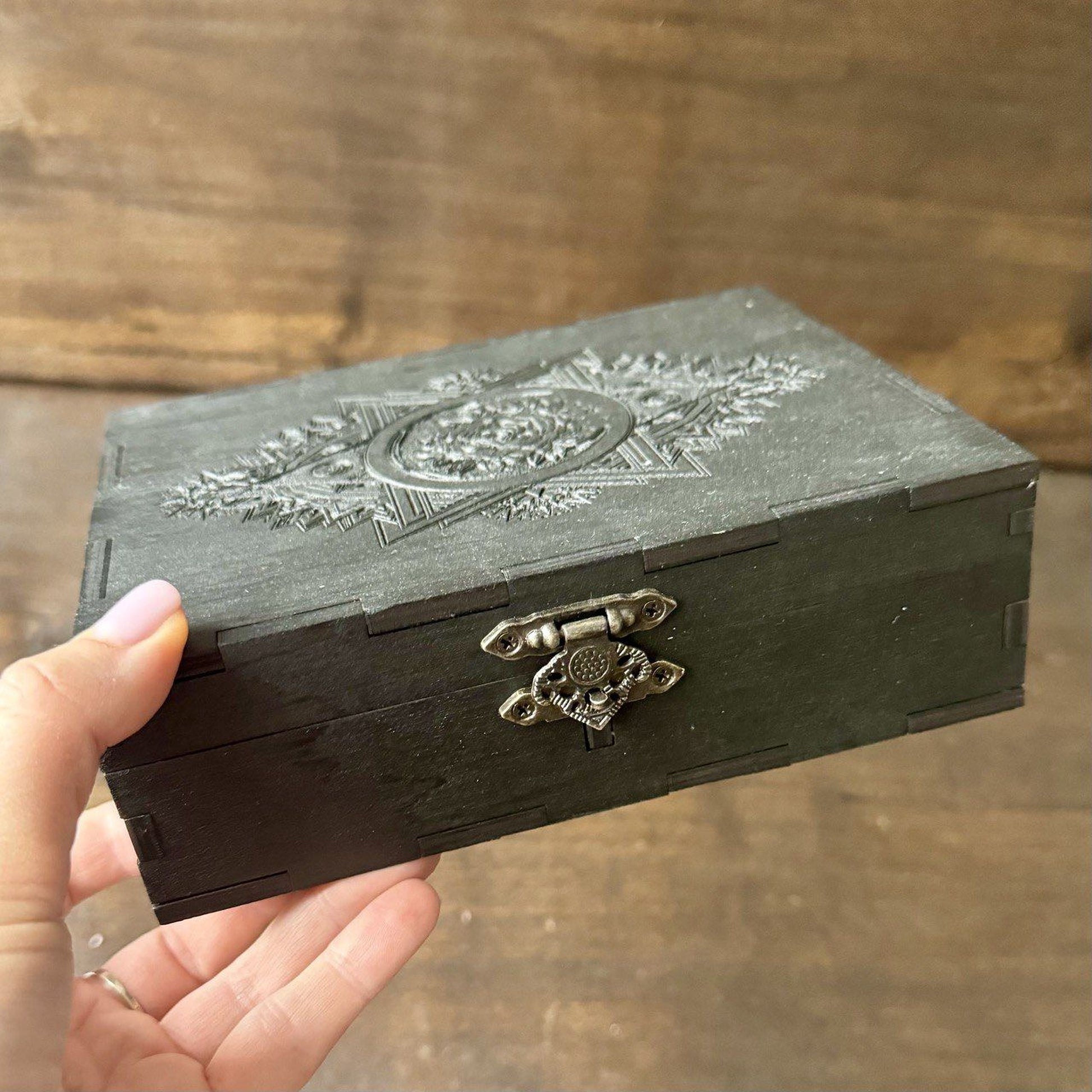 Close-up of engraved wooden tarot box with detailed esoteric symbols