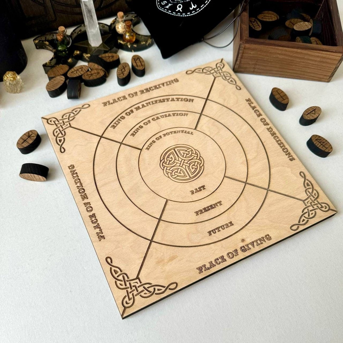 a wooden board game with a circular design and various text and symbols on it, along with some wooden tokens and other items on a table.