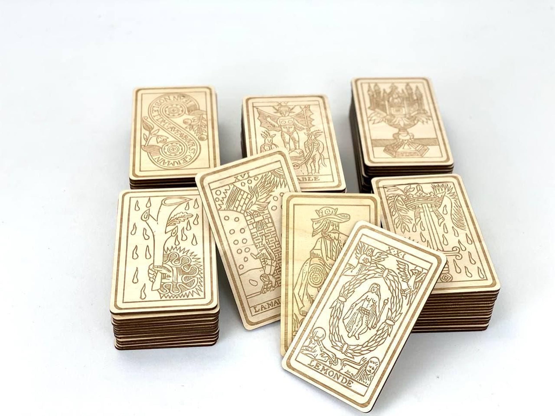 A collection of wooden tarot cards is displayed, with each card featuring intricate designs and illustrations.