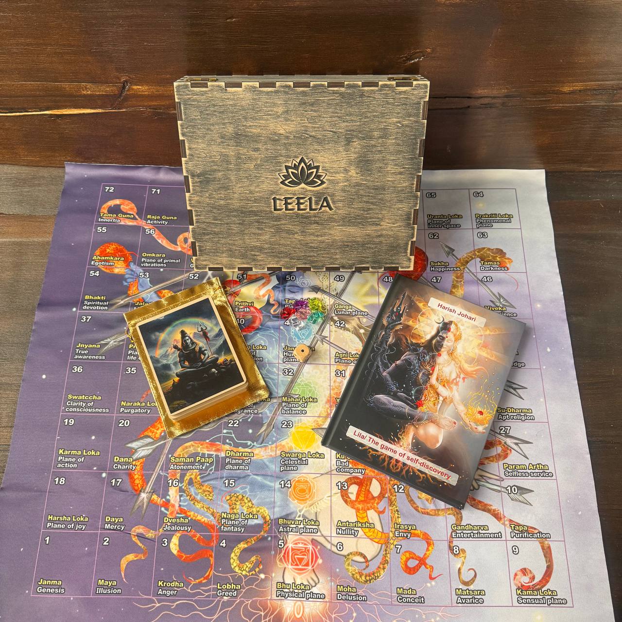 a wooden box with the word "LEELA" on it, a framed image, a book, and a map with various symbols and text.