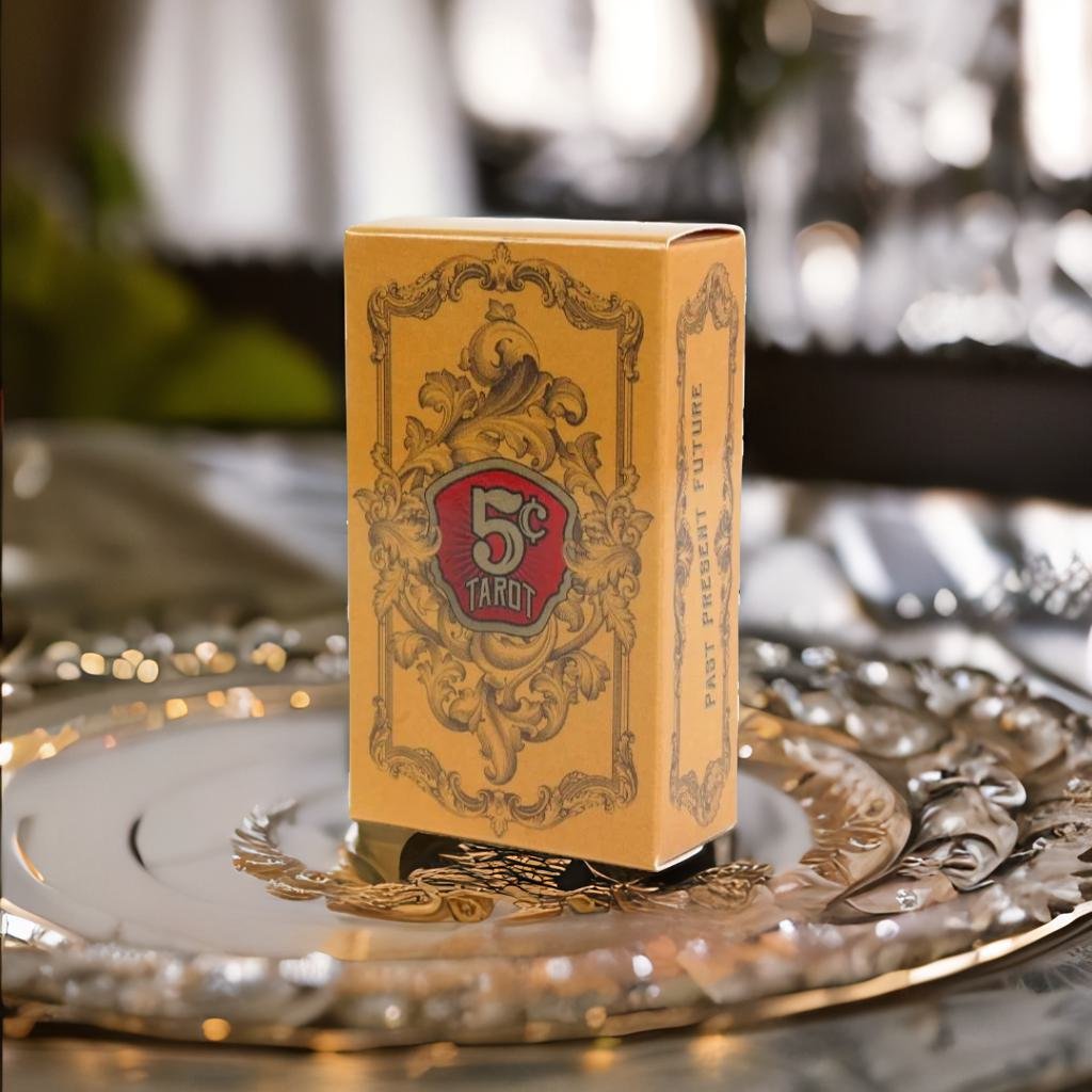 A yellow 5-card tarot box with a decorative border sits on a silver plate.