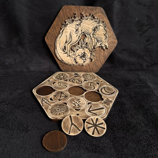 a wooden hexagonal puzzle with various symbols and designs carved into it, along with a wooden board with a carved image on it.