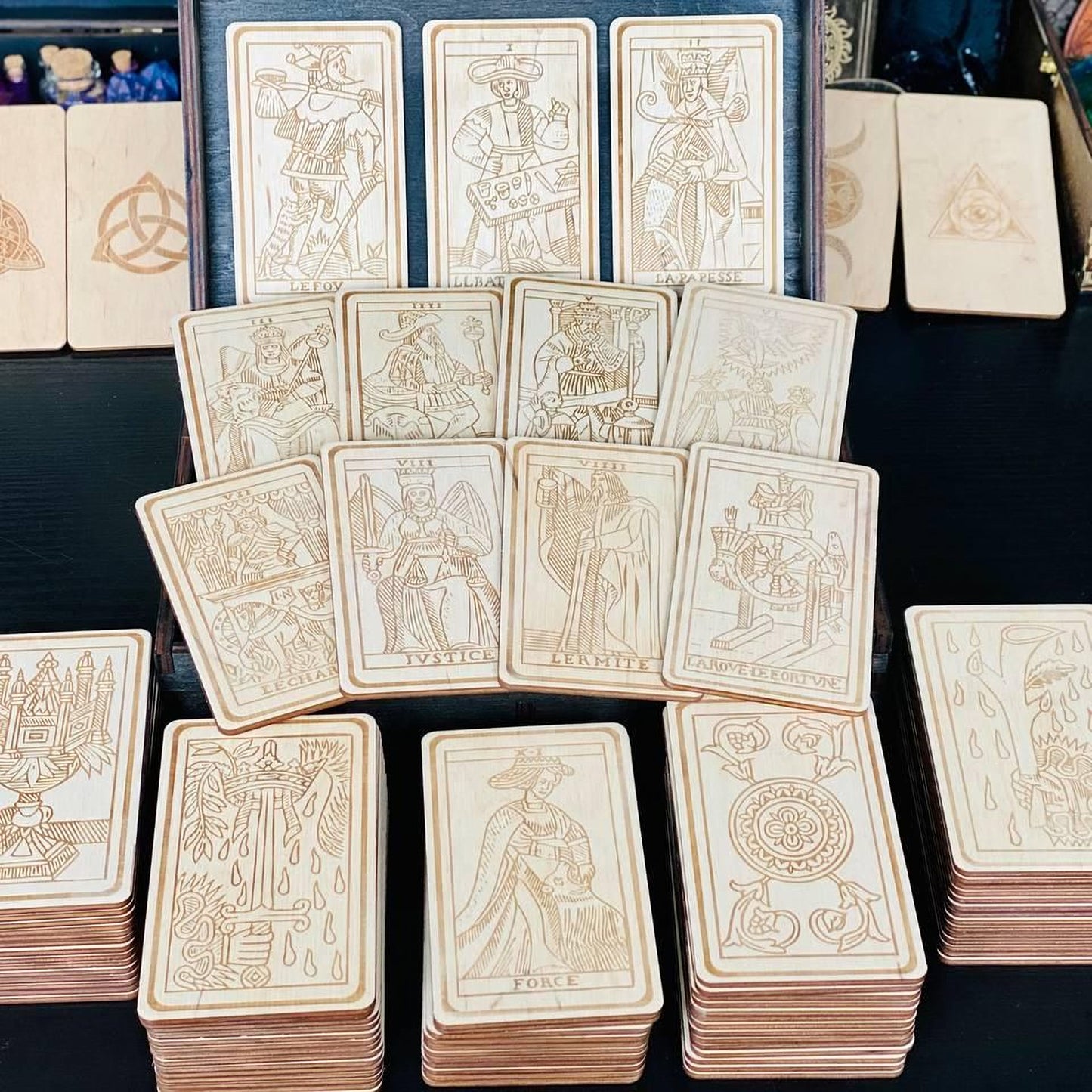 a collection of wooden tarot cards arranged on a table, with various designs and illustrations on the cards.