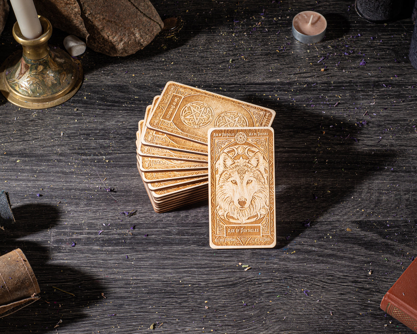 A stack of golden-brown tarot cards with a wolf illustration on the front, placed on a dark wooden surface.
