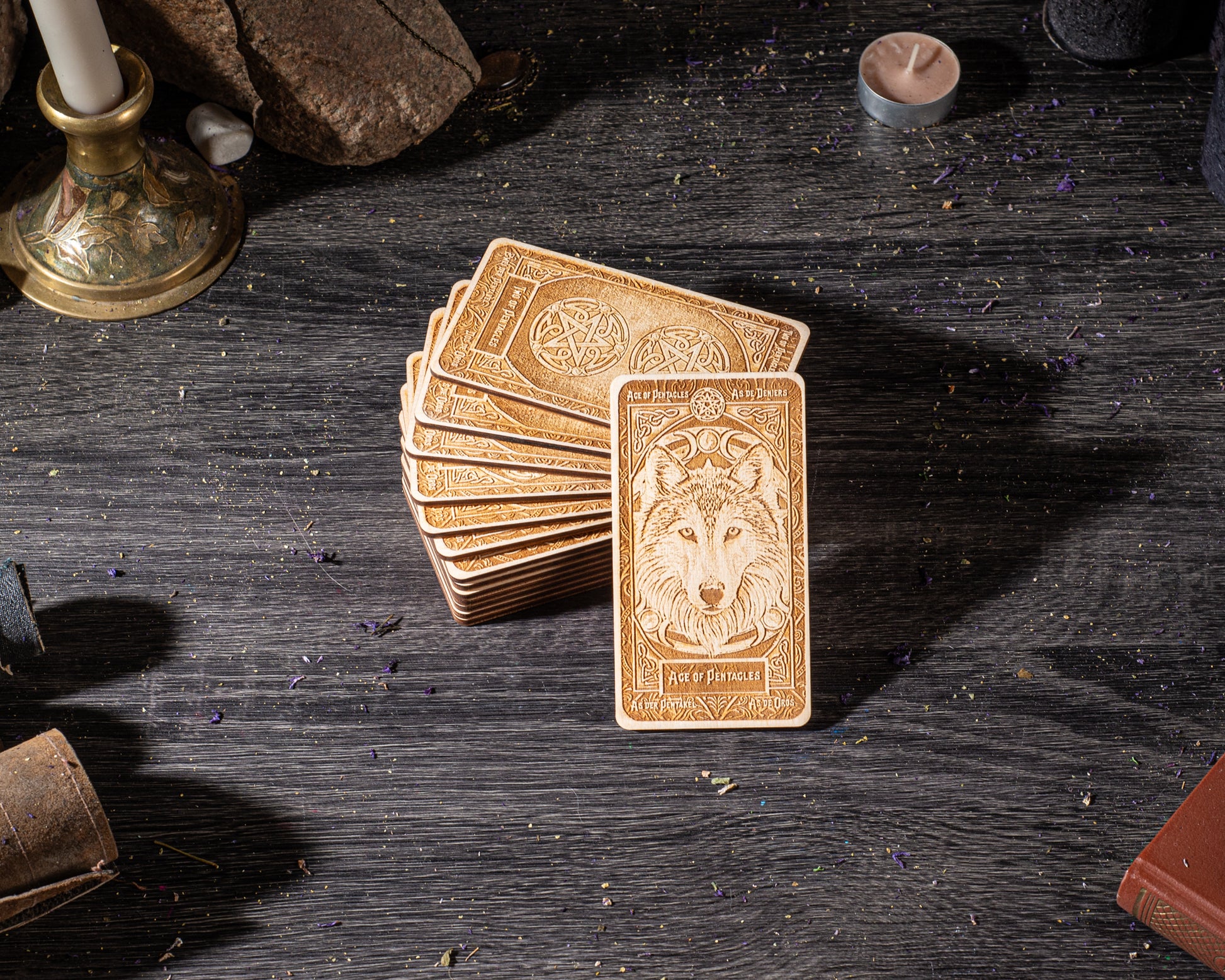 A stack of golden-brown tarot cards with a wolf illustration on the front, placed on a dark wooden surface.