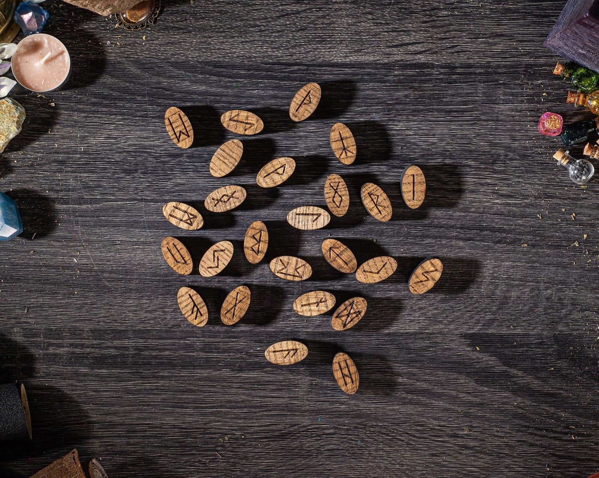 a collection of wooden symbols or charms arranged on a dark wooden surface.