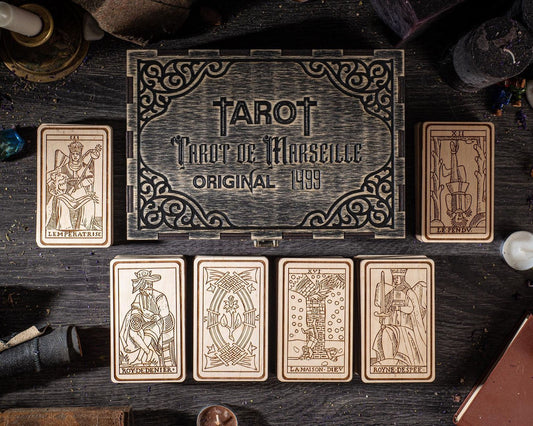 a collection of tarot cards and a wooden box with the text "Tarot de Marseille Original 1999".