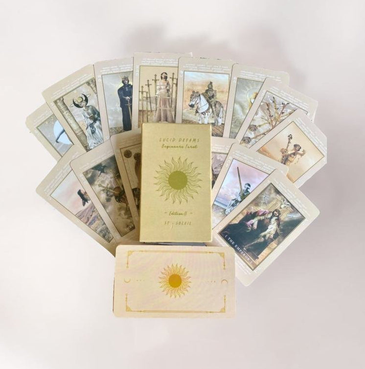 a collection of tarot cards arranged in a fan-like formation, with a central book titled "LUCID DREAMS" and a sun-like design on the front of the book.