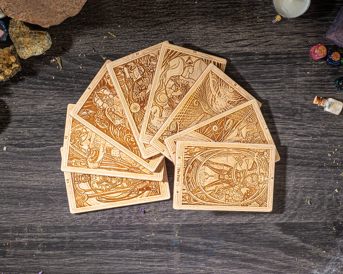 A deck of playing cards arranged on a wooden surface, with various designs and illustrations visible on the cards.