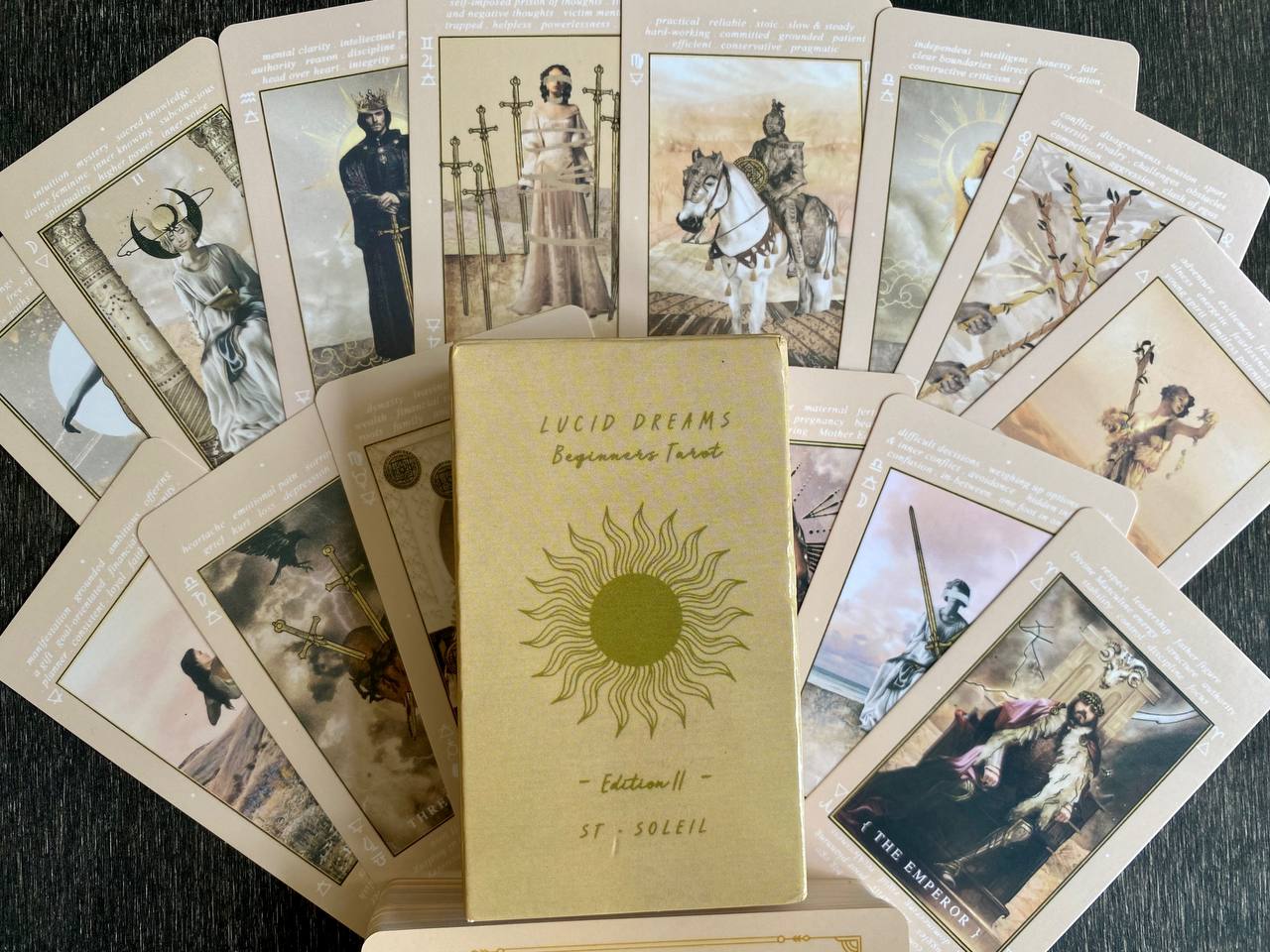 a collection of tarot cards arranged on a surface, with a book titled "LUCID DEFAMS" in the center.