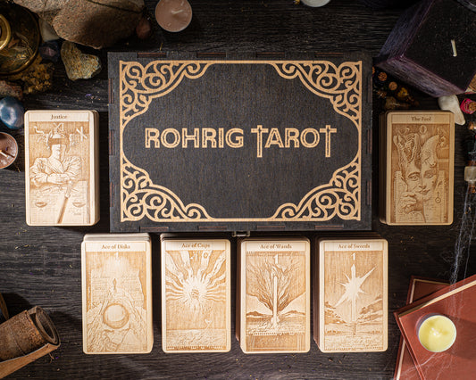 a collection of tarot cards arranged on a wooden surface, with a wooden box containing the cards in the center.