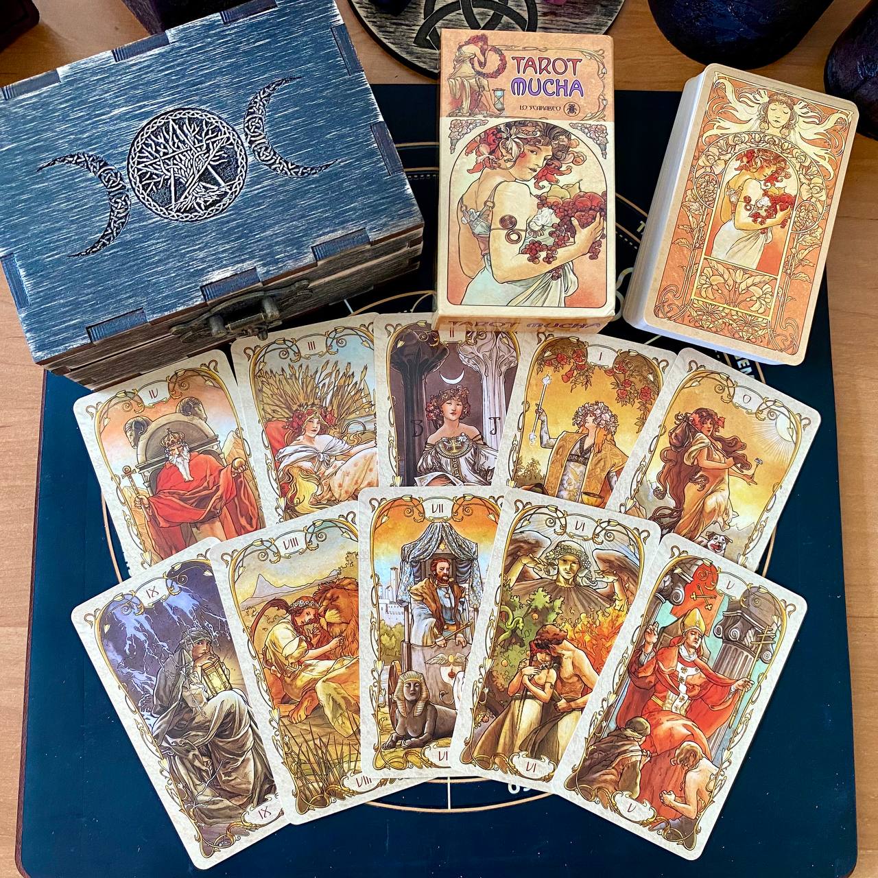 a collection of tarot cards and a wooden box, likely containing additional cards or accessories related to tarot reading.
