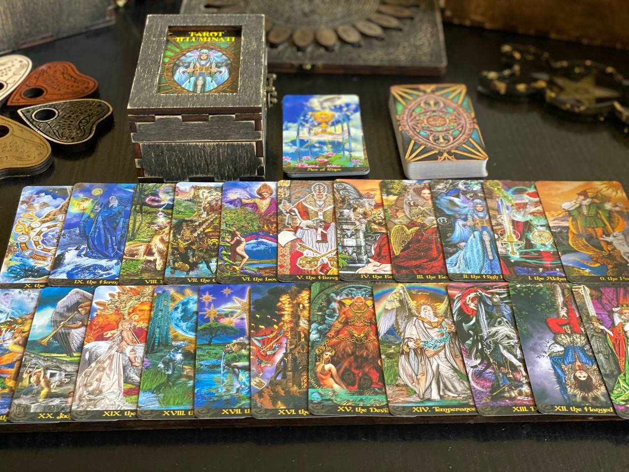 a collection of tarot cards arranged on a table, along with a wooden box and other objects.