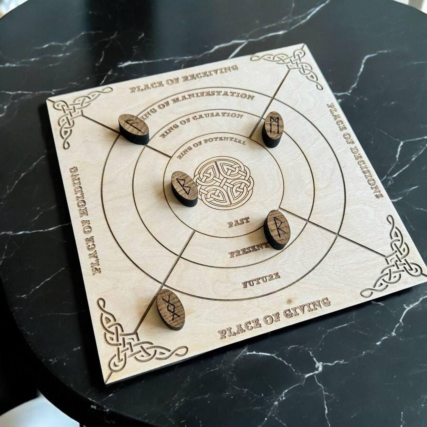A wooden board game with a circular design and wooden pieces, placed on a marble surface.