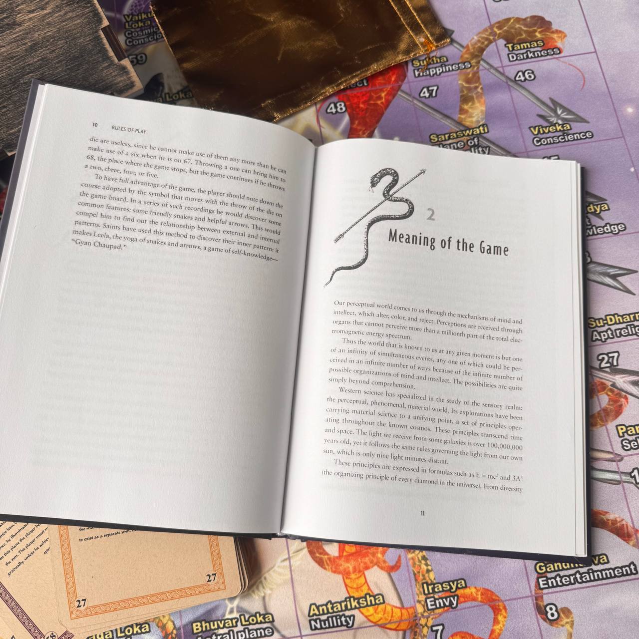 An open book with text on the right page, resting on a colorful map with various labels and symbols.