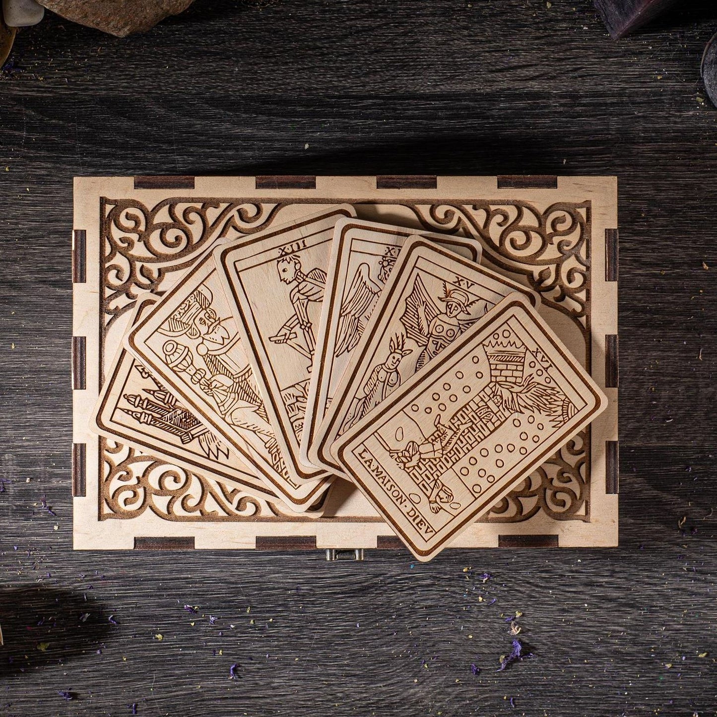 A wooden box with a decorative border, containing a set of wooden cards with intricate designs on them.