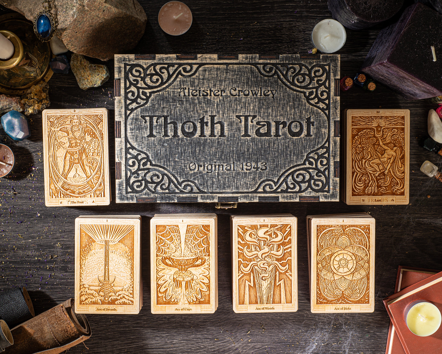 a collection of tarot cards arranged on a wooden surface, with a decorative box featuring the text "Thoth Tarot" and the number "1" prominently featured.
