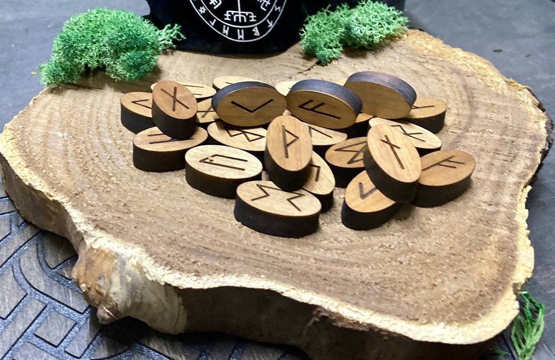a collection of wooden symbols, likely representing various spells or rituals, arranged on a wooden surface.