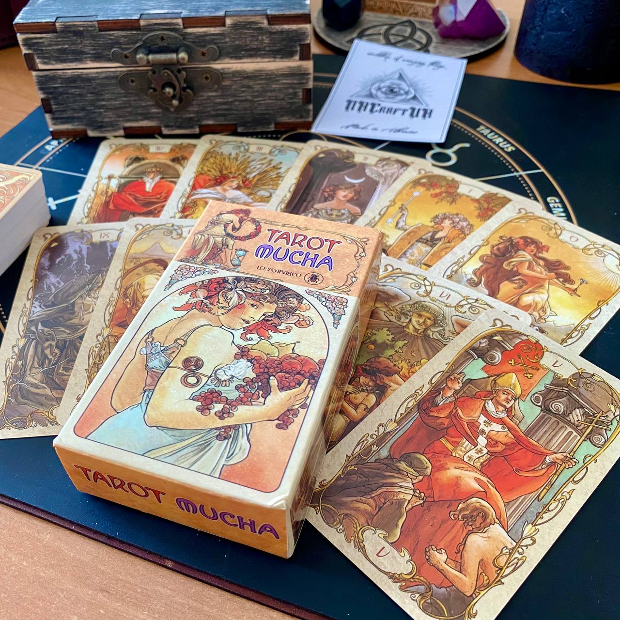 a collection of tarot cards and a wooden box, likely containing additional cards or accessories.