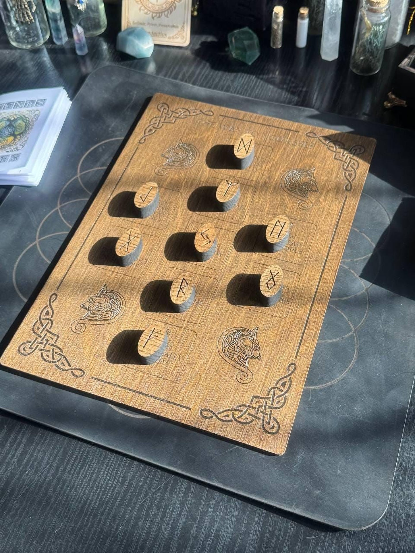 a wooden board with various symbols and markings, including what appear to be ancient symbols or symbols, possibly related to a mystical or magical theme.