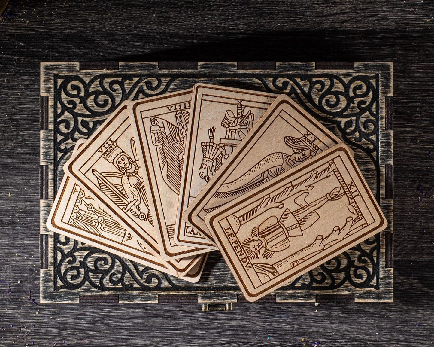 A collection of wooden playing cards arranged on a decorative wooden surface.