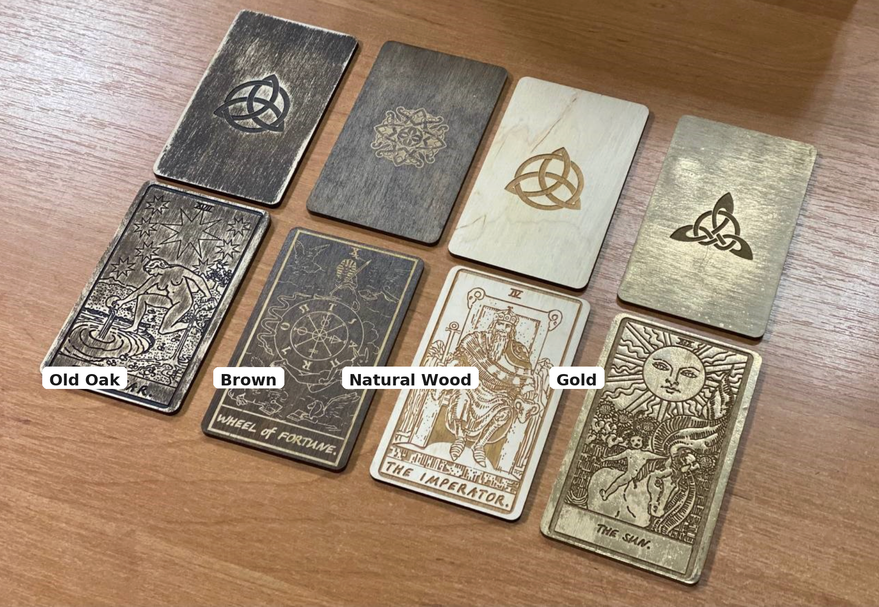 a collection of seven wooden tarot cards, each with a distinct design and color, arranged on a wooden surface.