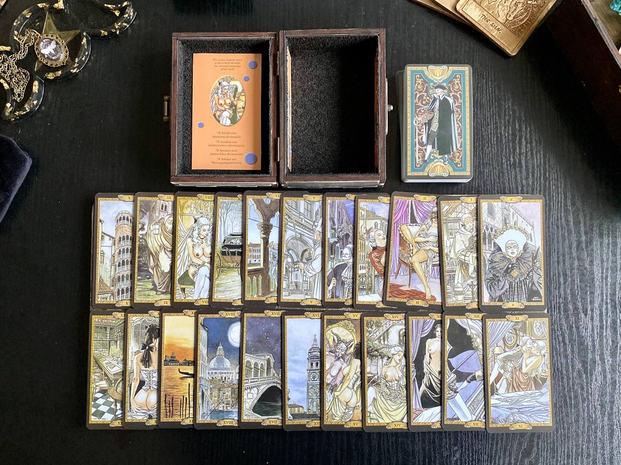 a collection of tarot cards arranged on a table, along with a wooden box and some decorative items.