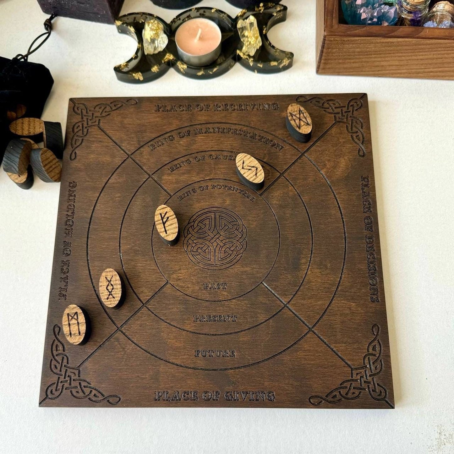 a wooden board with various symbols and text carved into it, placed on a white surface.
