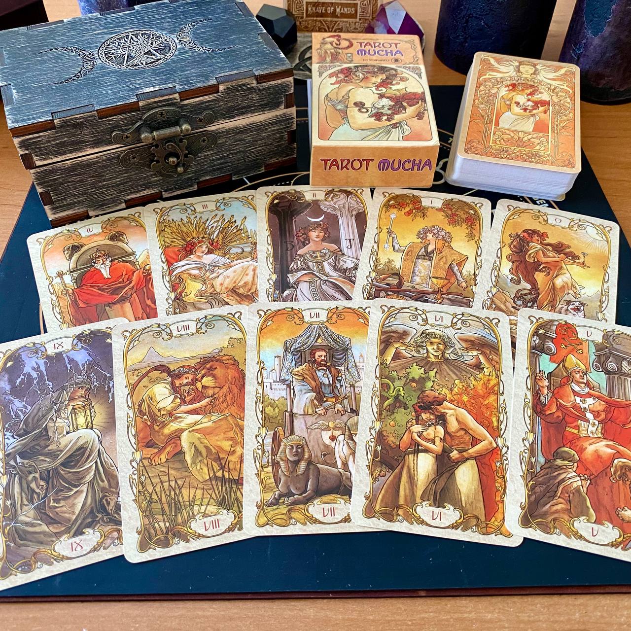 a collection of tarot cards and a wooden box, likely containing additional cards or accessories related to tarot reading.