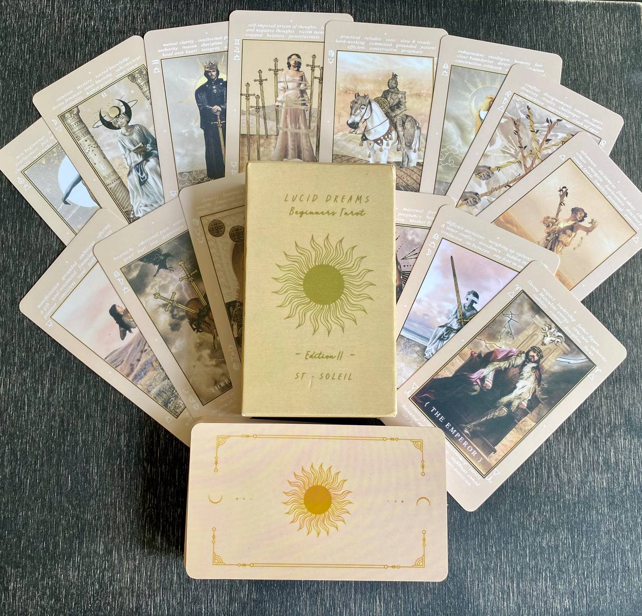 a collection of tarot cards arranged on a surface, with a book titled "LUCID DREAMS" in the center.