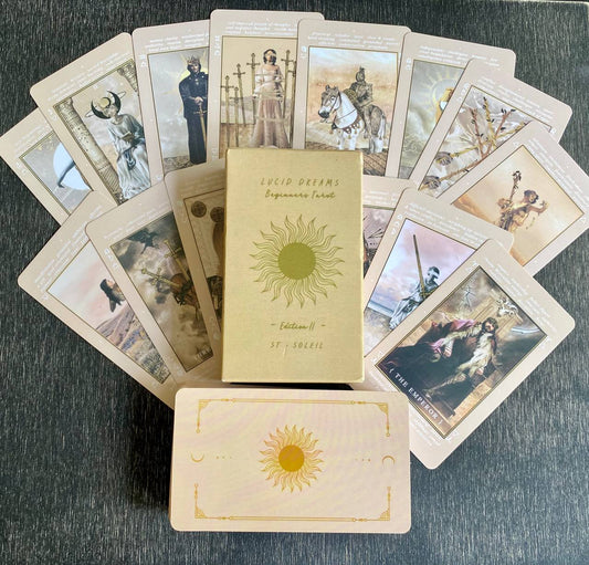 a collection of tarot cards arranged on a surface, with a book titled "LUCID DREAMS" in the center.