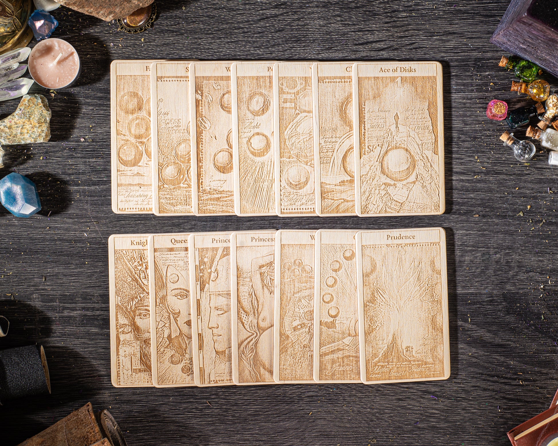 A collection of wooden tarot cards arranged on a dark wooden surface, with various objects scattered around them.