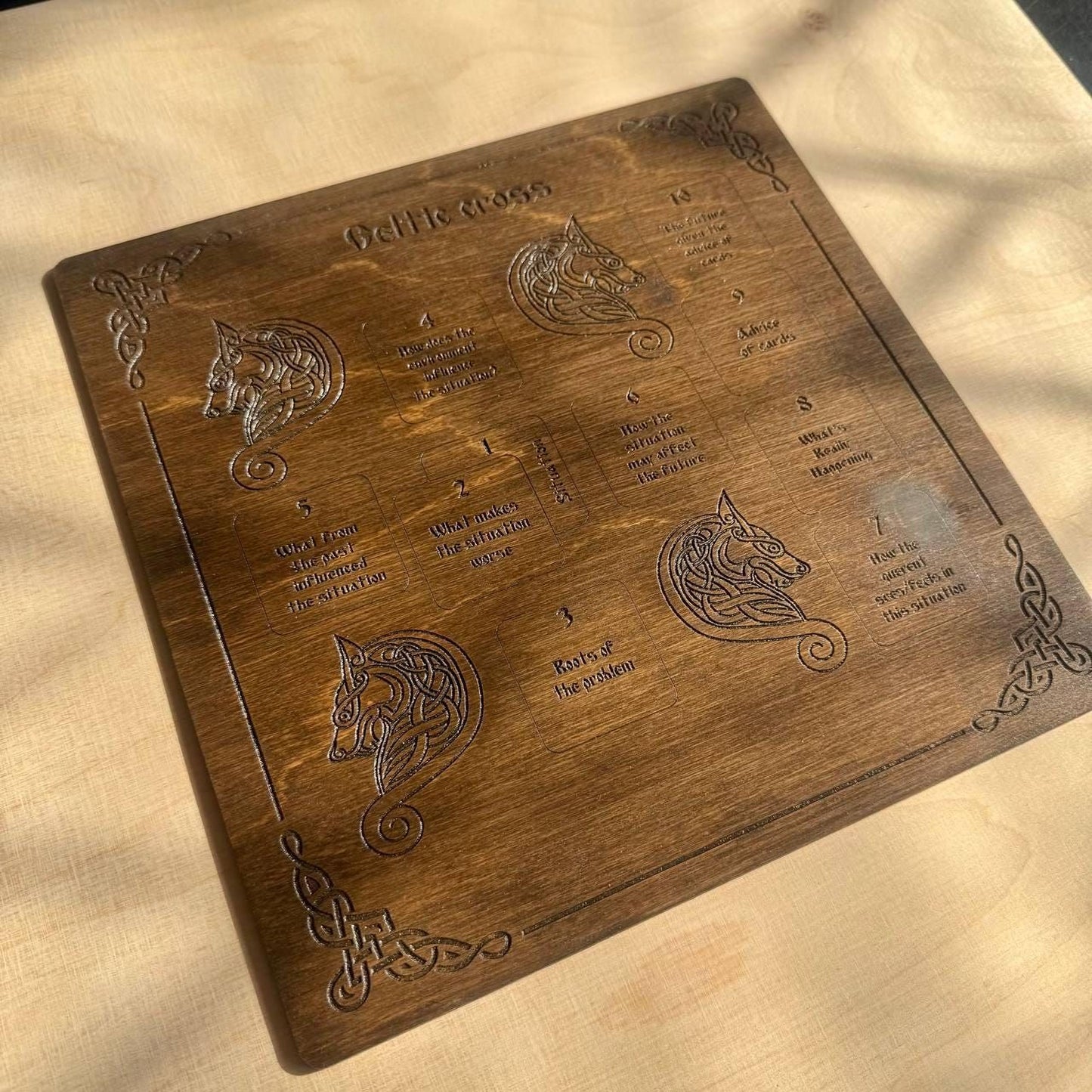a wooden board with intricate engravings of a wolf and a dragon, along with some text and symbols.