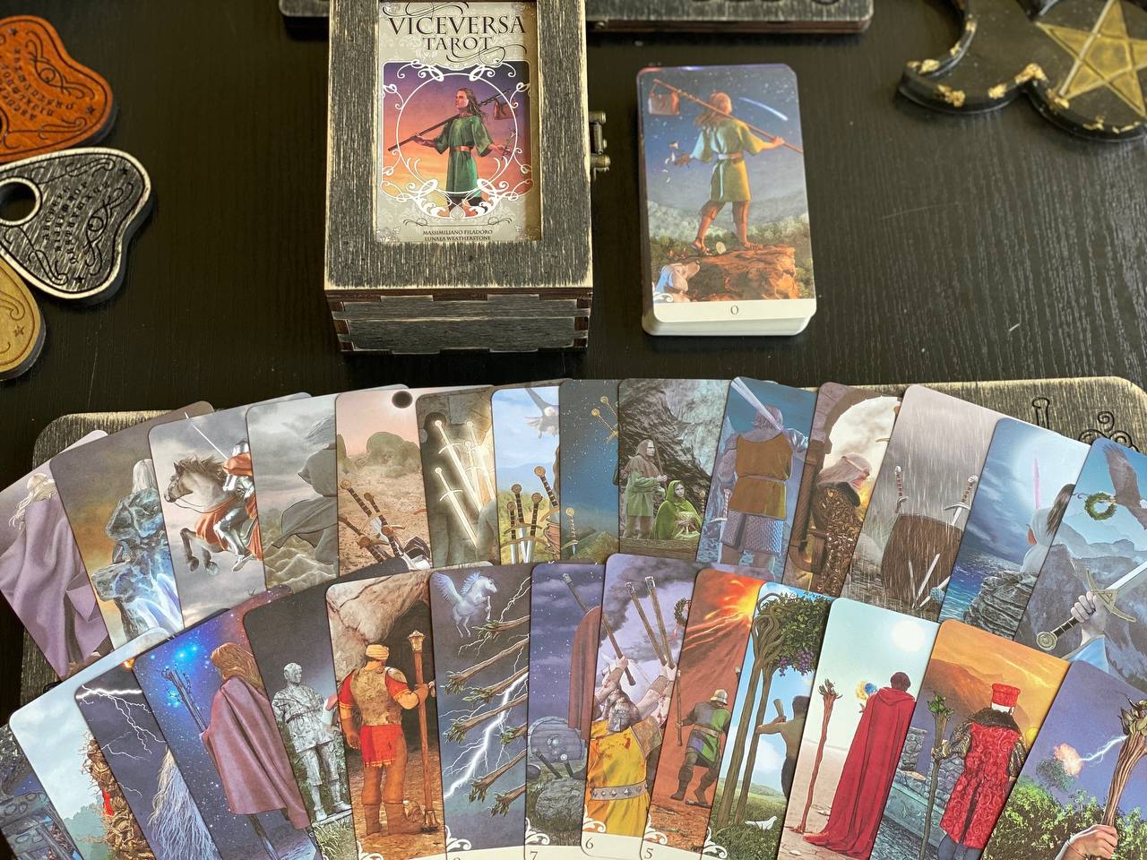 a collection of tarot cards and a wooden box, arranged on a table.