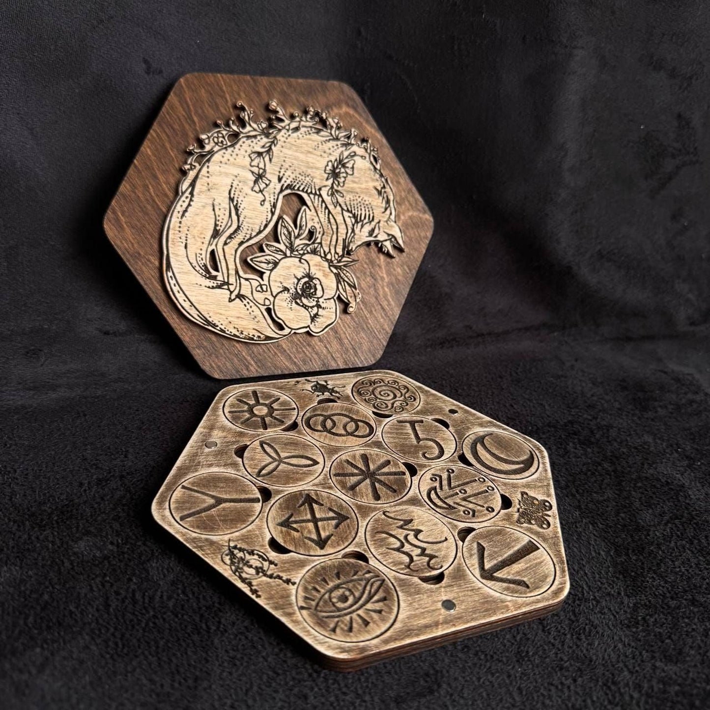 two wooden hexagonal objects with intricate designs and symbols carved into them.