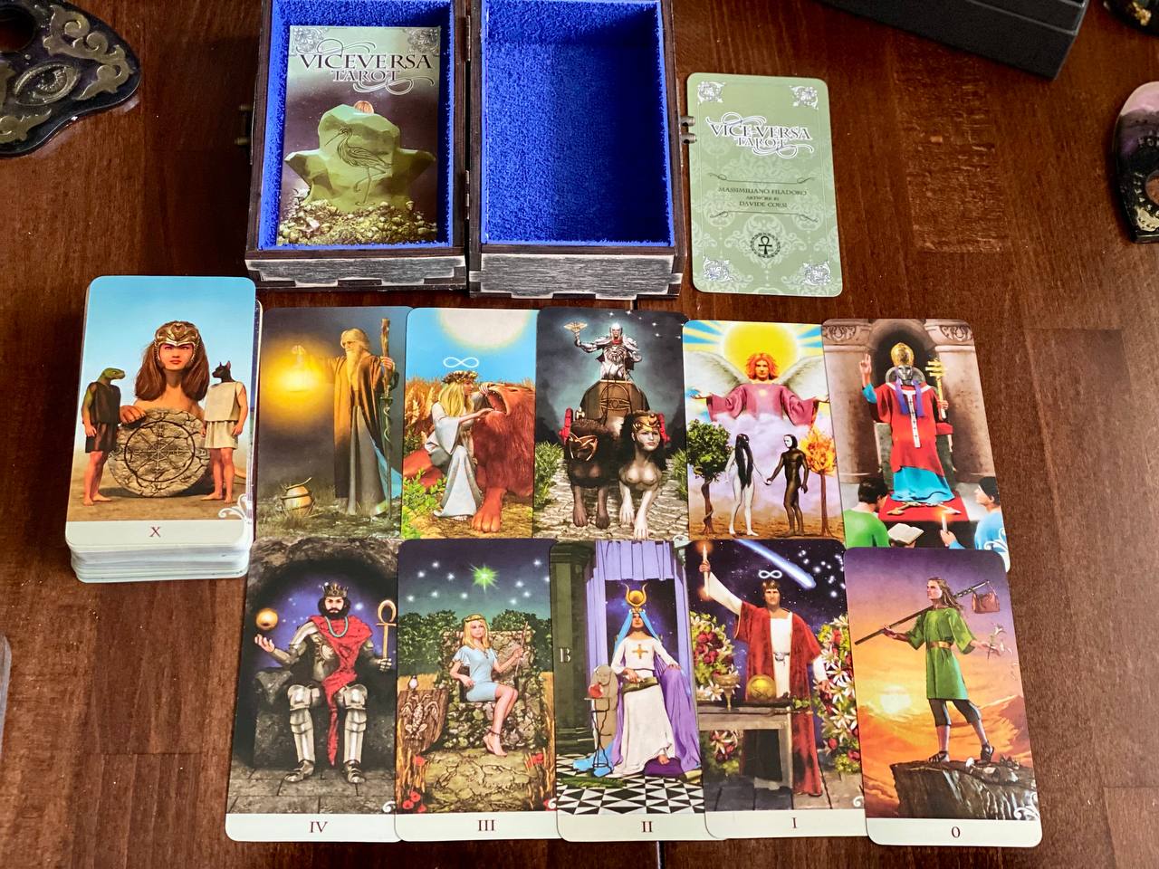 a collection of tarot cards and a blue box, arranged on a wooden surface.