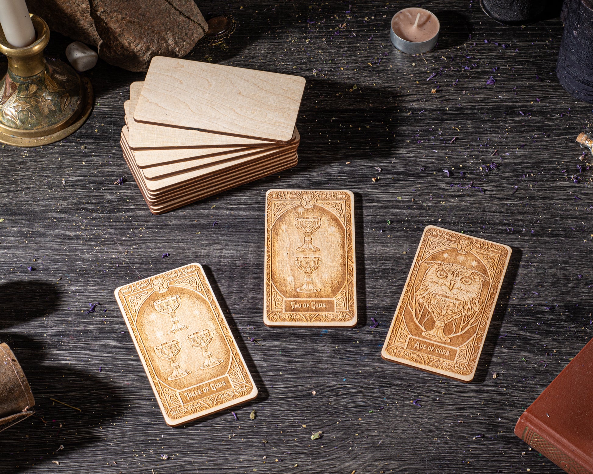 three wooden cards with intricate designs, placed on a dark wooden surface.