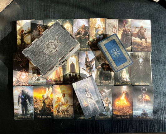 a collection of tarot cards and a wooden box, arranged on a dark surface.