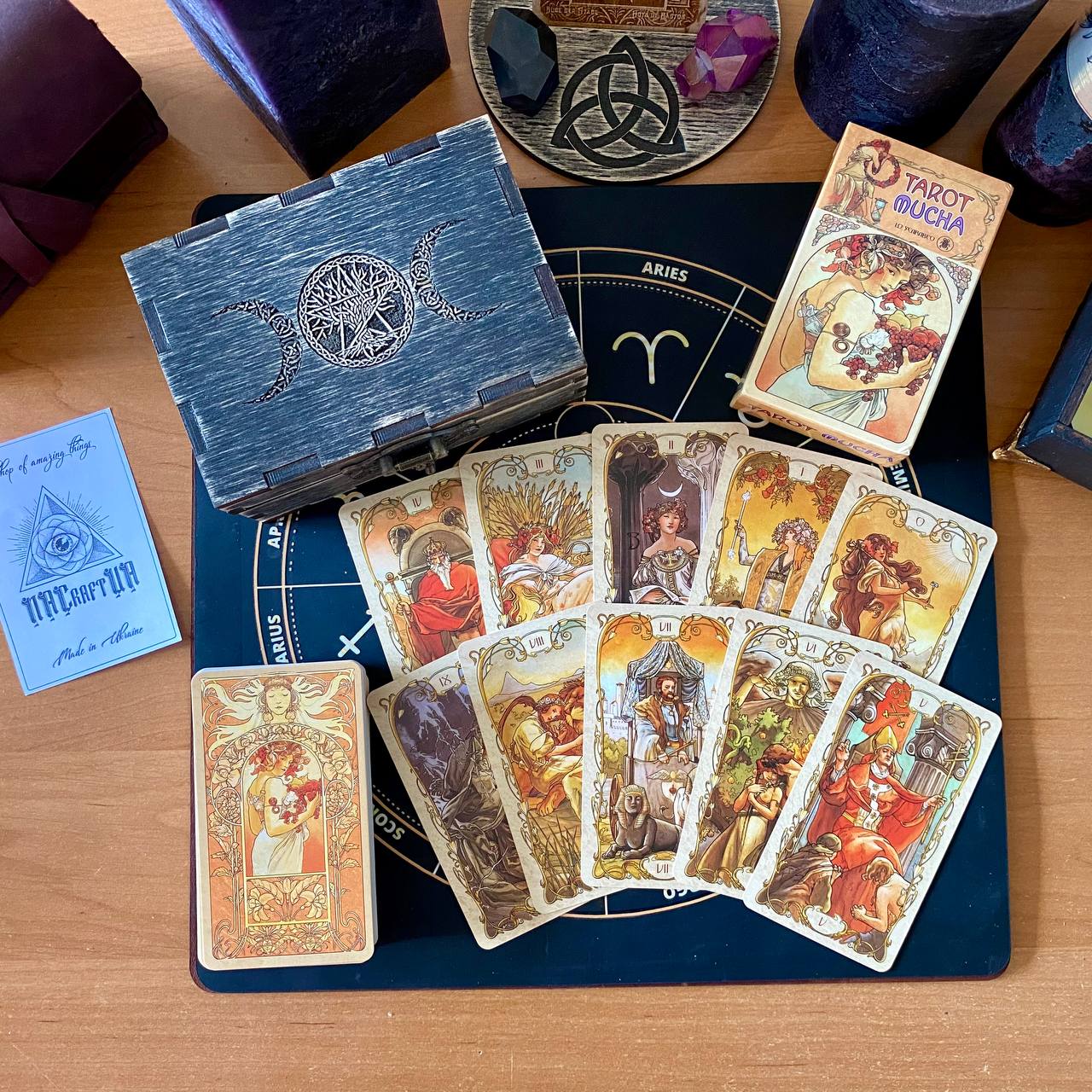 a collection of tarot cards, a fortune teller's deck, and various other items arranged on a wooden surface.