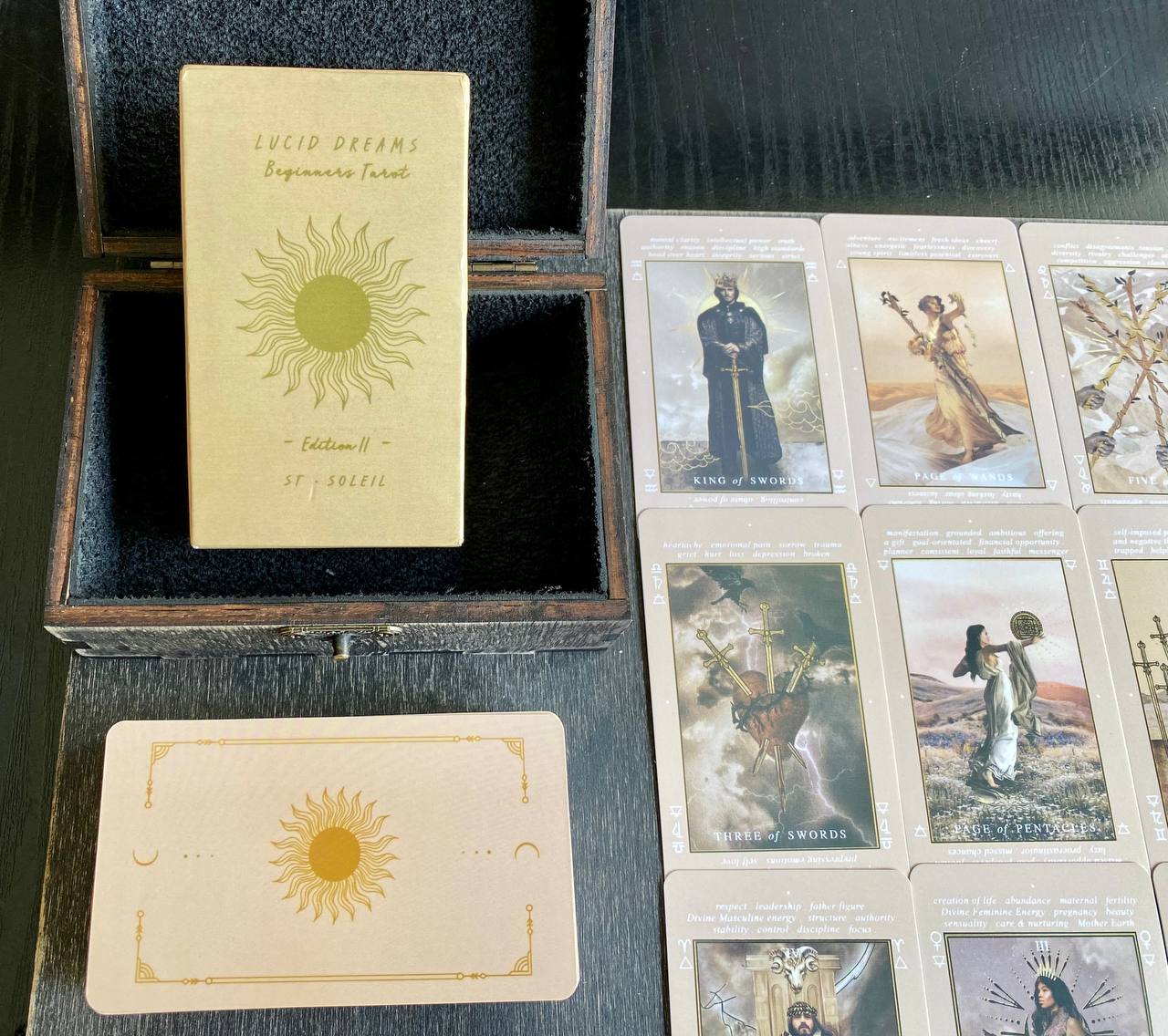 a collection of tarot cards and a box of Lucid Dreams cards, arranged on a wooden surface.