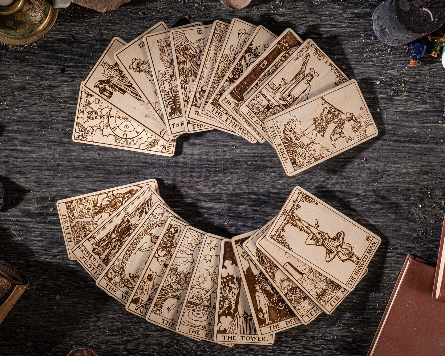 A collection of tarot cards arranged in a circular pattern on a wooden surface, with various illustrations and text.