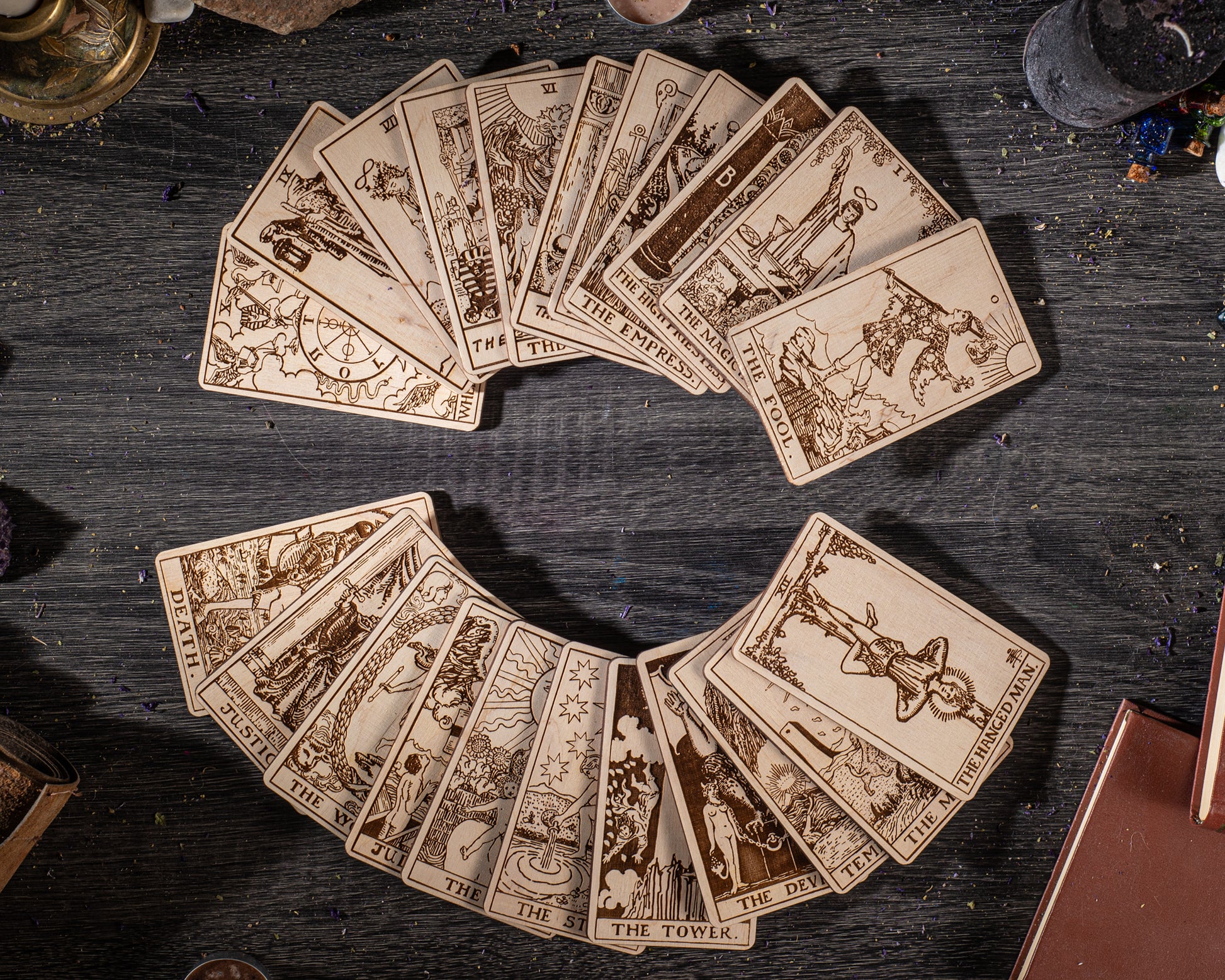 A collection of tarot cards arranged in a circular pattern on a wooden surface, with various illustrations and text.