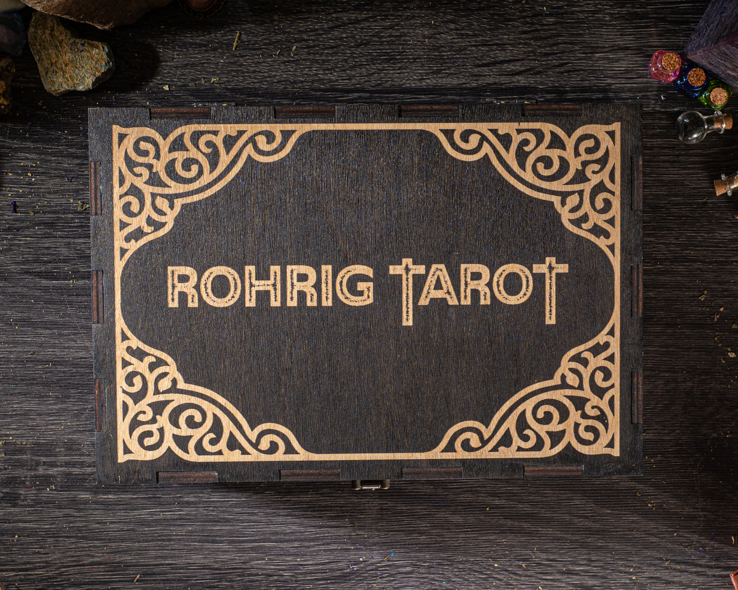 A wooden box with the name "Rohrig Tarot" embossed on it, placed on a wooden surface.